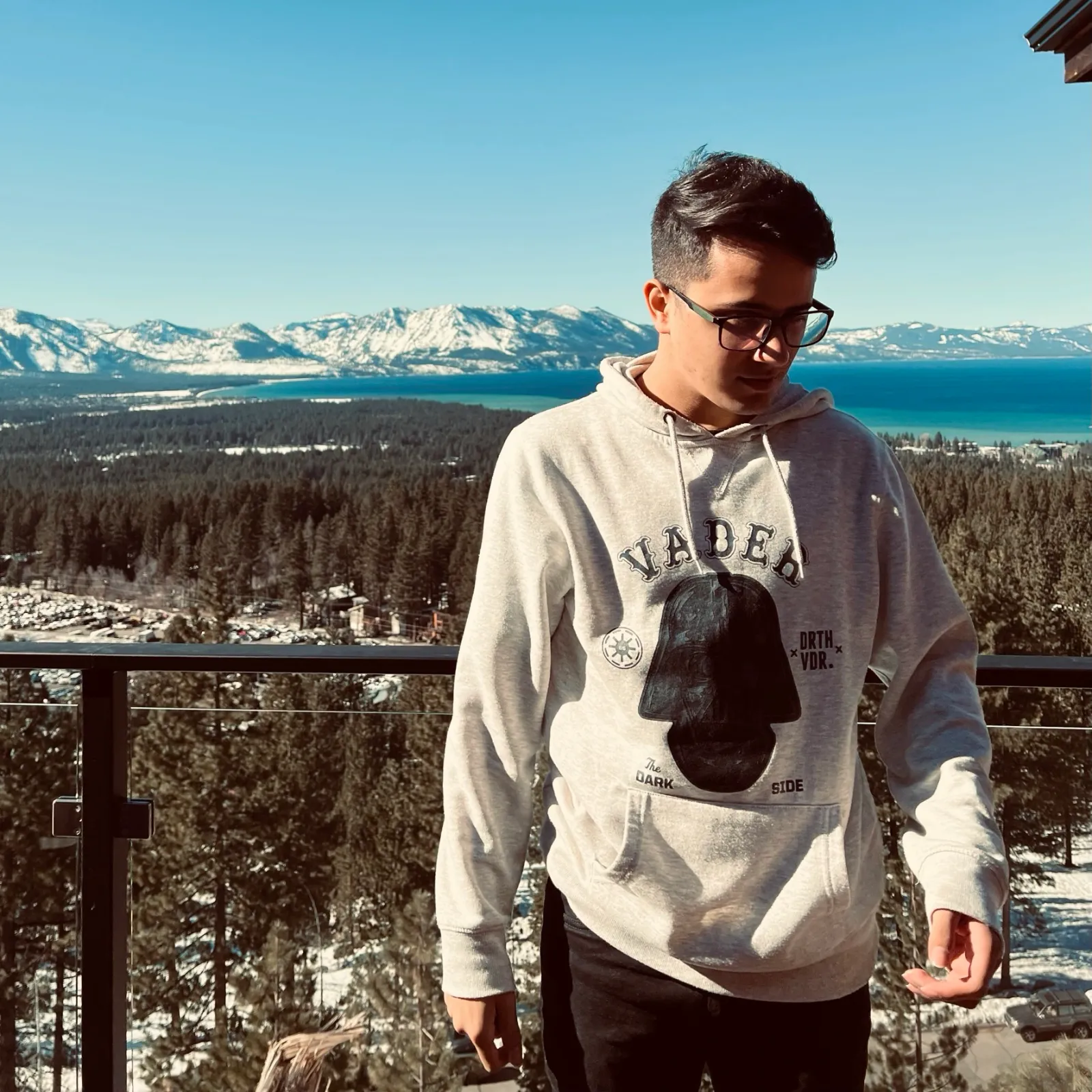Photo of myself, on a balcony, with a lake and a snowy mountain behind me.